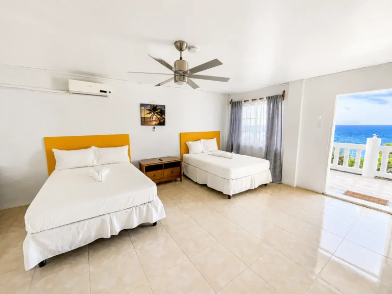 Two double beds with ocean view in Coastal Vista Room 2 at Da Villa Juanita