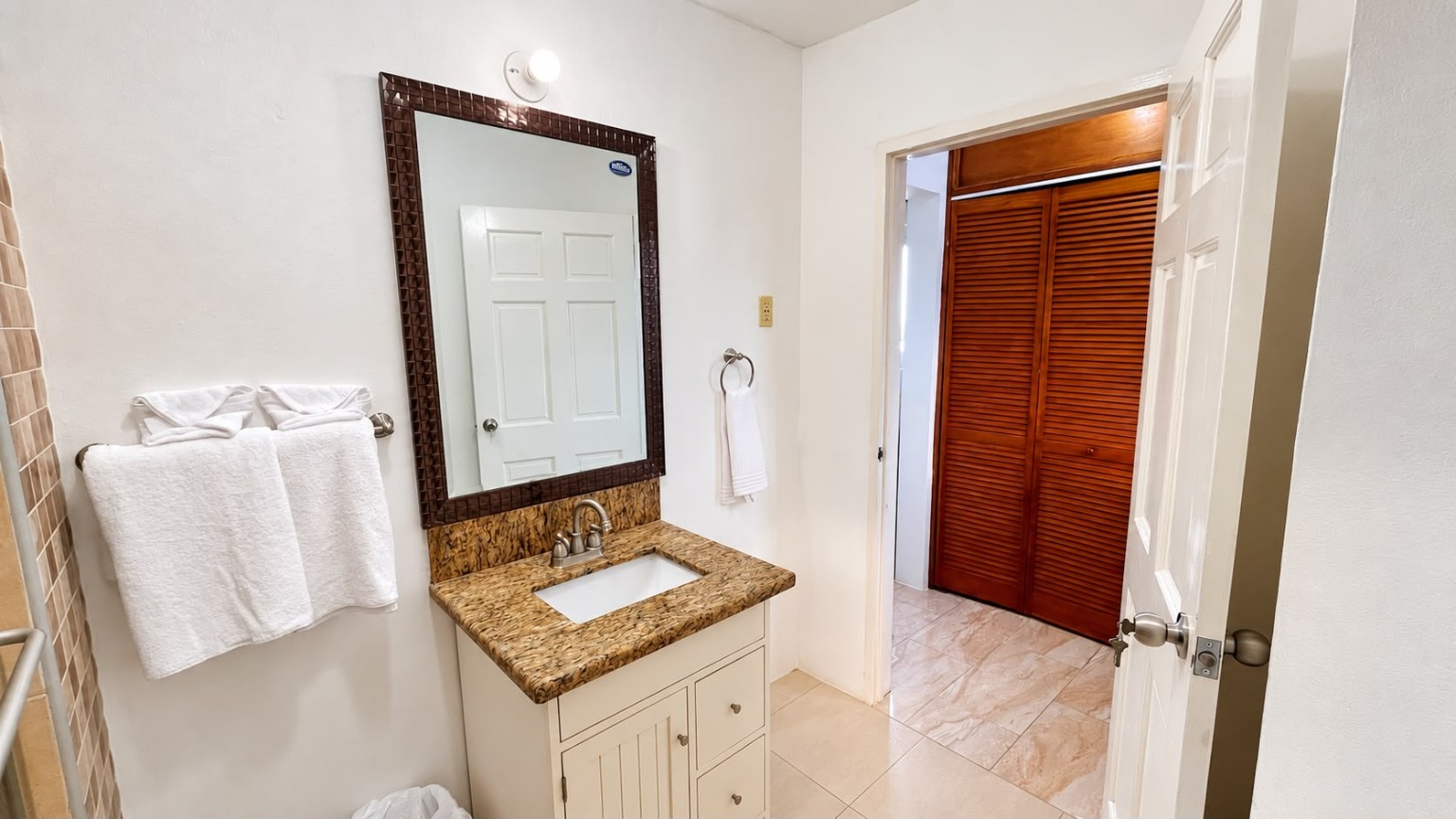 Grand Pavilion ensuite bathroom vanity with towels and closet area at Da Villa Juanita